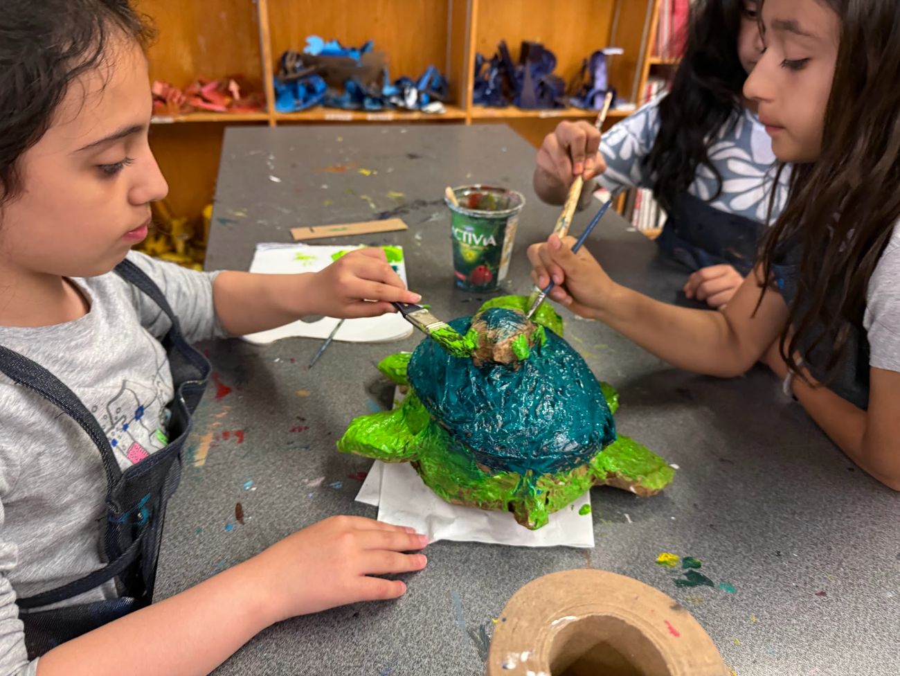 Children painting a handmade turtle sculpture